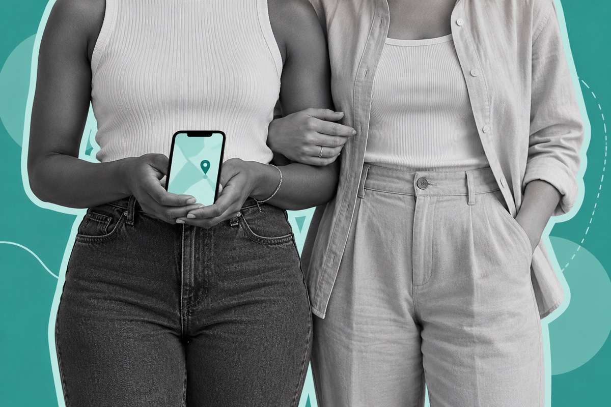 Two women shown from the shoulders down stand together beside a smartphone displaying a simple map marker
